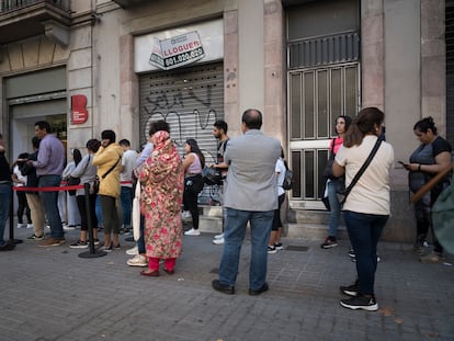 Personas frente a la Oficina de Prestaciones sociales del ayuntamiento de Barcelona, en una imagen de archivo de 2022.