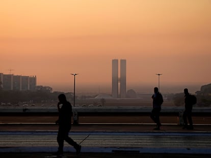 Transéuntes caminan entre el humo ocasionado por un incendio forestal en Brasilia, Brasil, el 16 de septiembre de 2024.