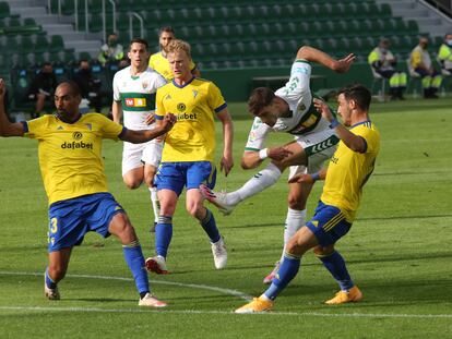 El delantero del Elche Lucas Boyé dispara a puerta rodeado de defensores del Cádiz.