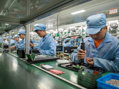 Empleados montan circuitos en una cadena de montaje  en la provincia china de Zhejiang