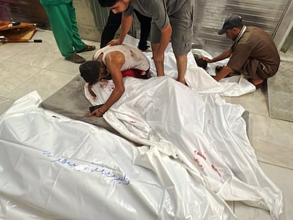 Un hombre llora sobre el cadáver de un familiar en un hospital de Gaza.