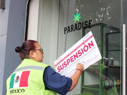 Una inspectora de la Cofepris coloca un sello de suspension en la entrada de una tienda Paradise, en el centro de Ciudad de México.