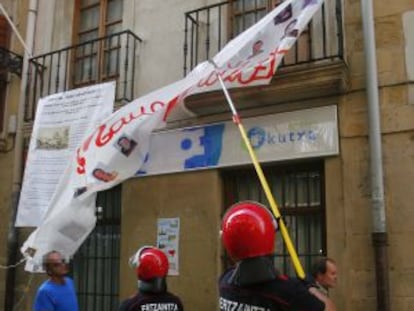 Agentes de la Ertzaintza retiran ayer una pancarta en San Sebastián.