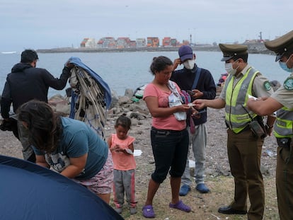 Carabineros chilenos revisan los documentos de una familia de migrantes venezolanos, en Iquique (Chile), en una imagen de archivo.