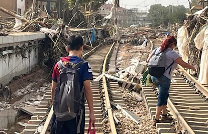 Una madre y su hijo, caminan por las vías destrozadas del Metro de Paiporta.