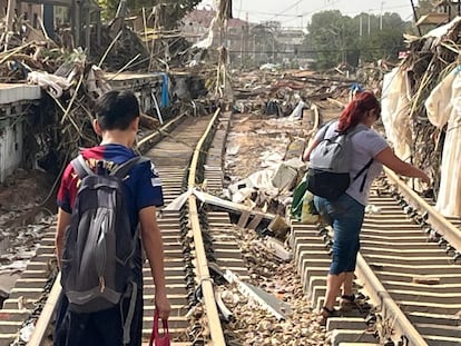 Una madre y su hijo, caminan por las vías destrozadas del Metro de Paiporta.