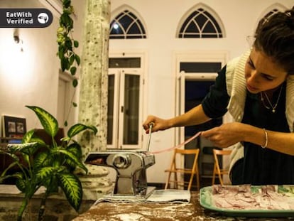 Una mujer asociada al colectivo virtual Eat With prepara la comida para compartir.