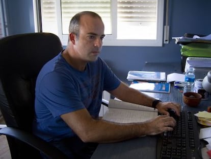 Julio Salom, ante el ordenador, en su casa.