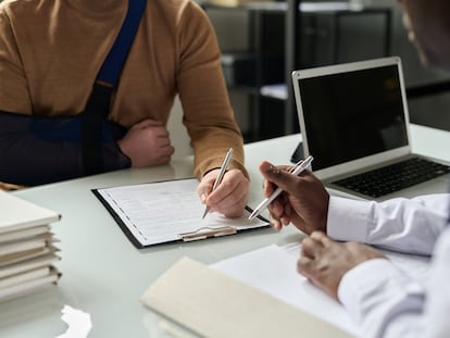 Un trabajador rellena información sanitaria en la consulta médica.