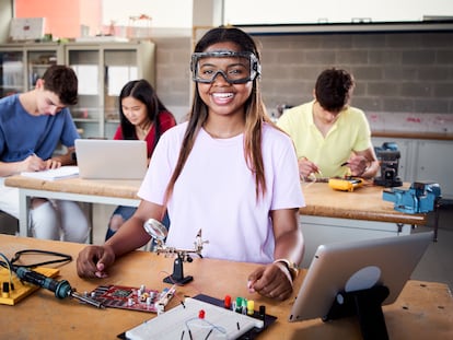 Una estudiante de Formación Profesional con gafas de seguridad sonríe en un momento de su clase.