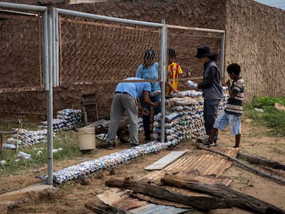 Miembros de la ONG La Papelera Tiene Hambre construían un muro con 'ecobloques' en la escuela Luz del Saber, en diciembre de 2022 en Maracaibo (Venezuela).