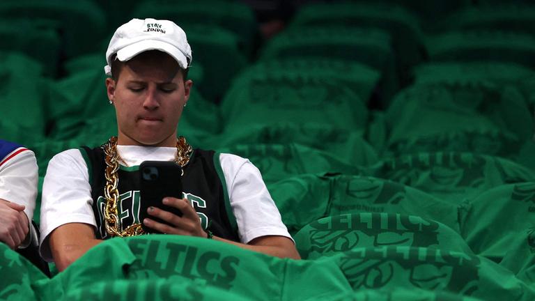 Fan der Boston Celtics mit Mobiltelefon