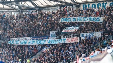 Hansa Fans im Block 9 mit dem Spruchband: Christian der Sextourist, der die Liebe zum Verein vergisst