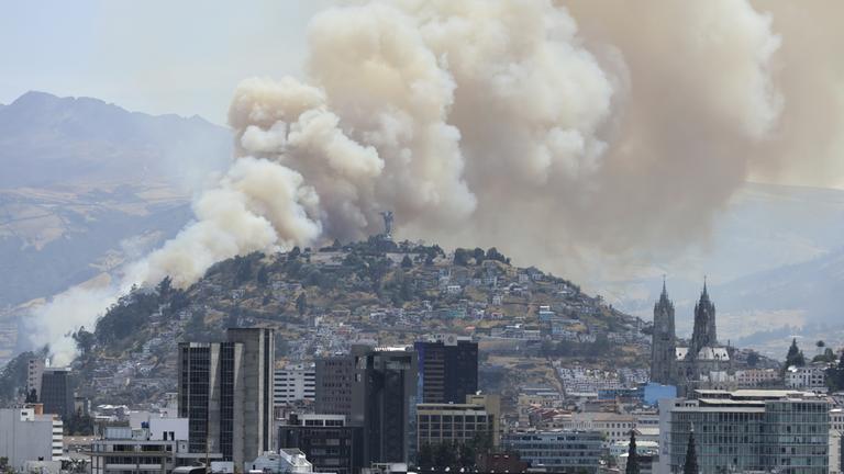 Rauch von einem Waldbrand bedeckt einen Hügel in Quito, Ecuador