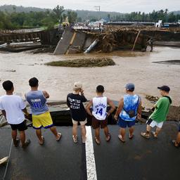 Menschen schauen auf eine durch den Sturm "Trami" zerstörte Brücke in der philippinischen Provinz Batangas.