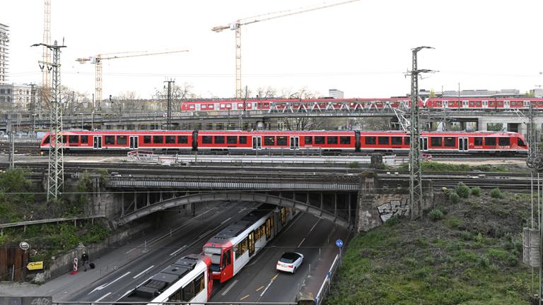 Züge überqueren eine Eisenbahnbrücke am frühen Morgen am Deutzer Bahnhof in Köln.