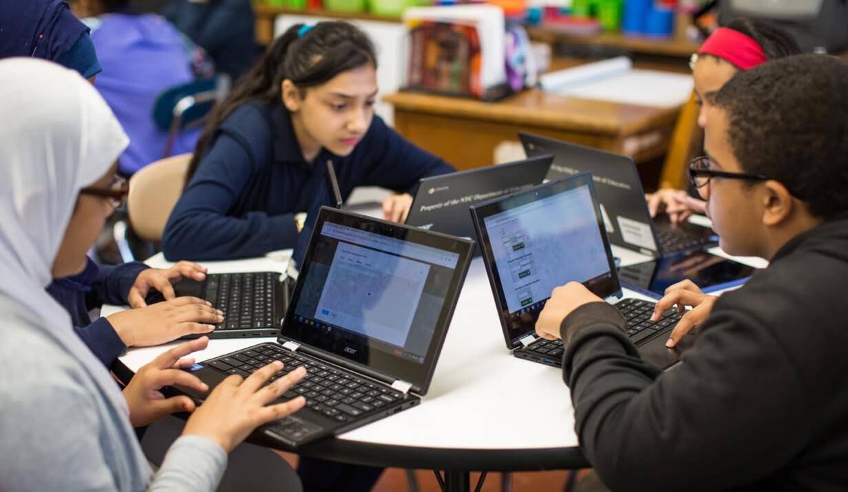 Quatre élèves d'une école du Moyen-Orient travaillent ensemble à une table ronde