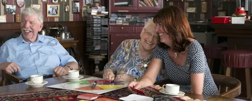 Elderly couple playing game and laughing with caregiver