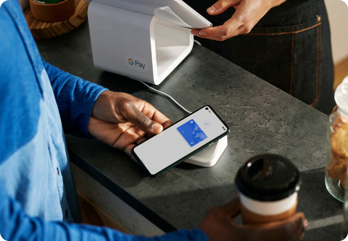 someone using Google Pay to pay for their burger and fries at a restaurant