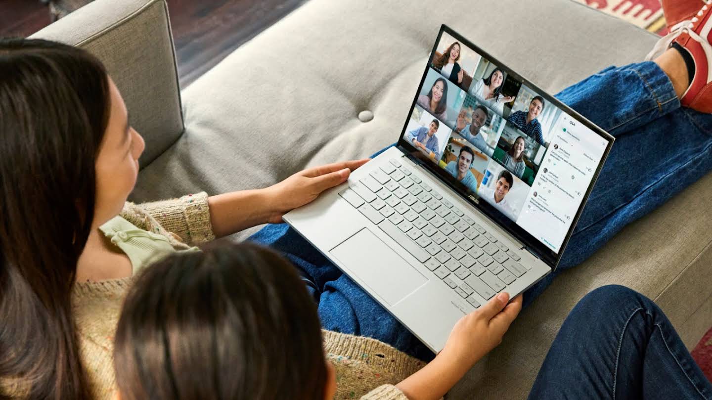 Dwie osoby siedzą na kanapie i uczestniczą w rozmowie w Google Meet.