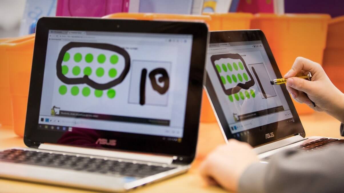 Un enfant écrit sur un Chromebook tactile à l'aide d'un stylet