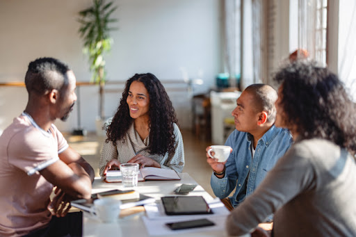 A group of four coworkers have a work meeting.