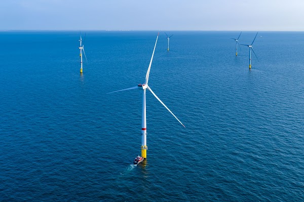 Six éoliennes en mer sur fond de ciel bleu