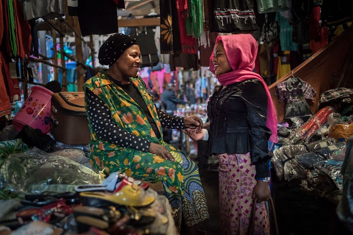 Djamila discute avec une autre femme sur un marché de Bukavu.