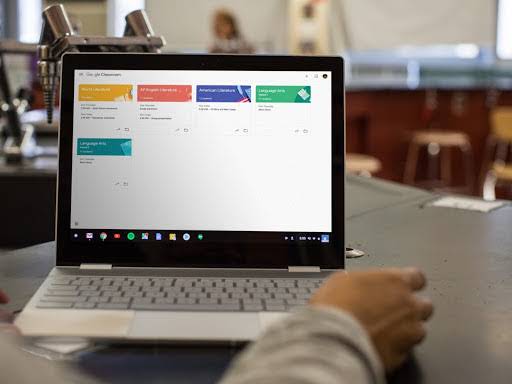 Tampilan dekat Chromebook di meja dengan layar menampilkan Classroom.