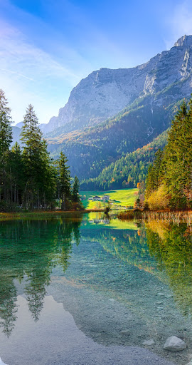 A photo of a mountain lake, split in the middle vertically. The left side is in crisp, vibrant Ultra HDR, the right side is in standard definition.