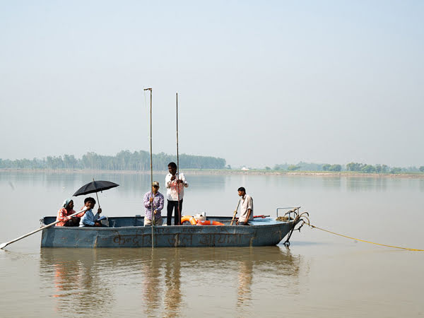 Équipage de bateau en train de mesurer la profondeur de la rivière en Inde