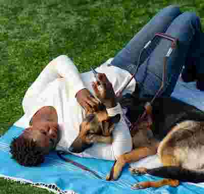 A person lying down with their dog.