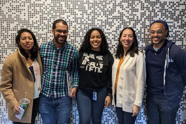 A group of five Googlers stand together and smile at the camera