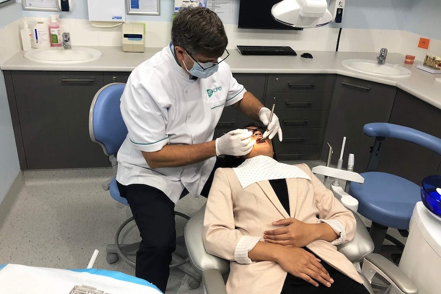 Dentist with a patient in a dental chair.