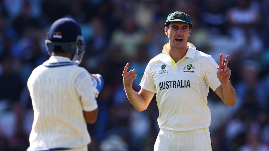 Pat Cummins givning hand signals while captaining in the cricket field