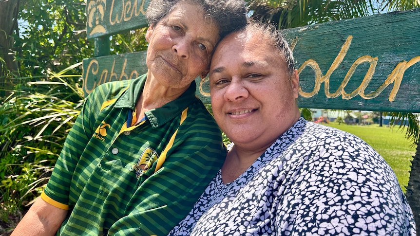 two women in front of Cabbage Tree Island sign