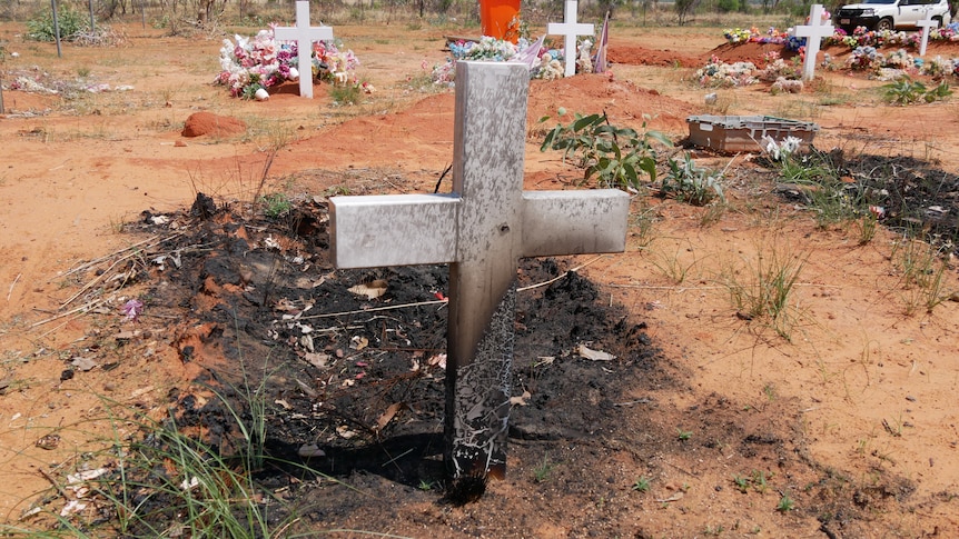 Te back of a burnt cross in a cemetery