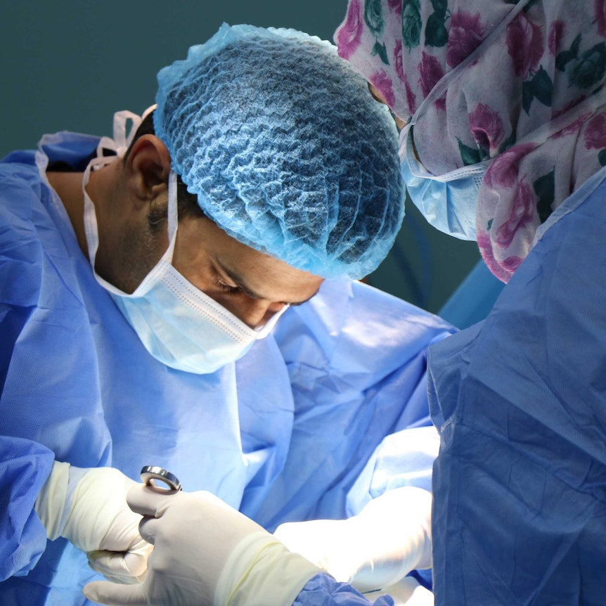 A doctor and nurse in an operating room in a hospital.