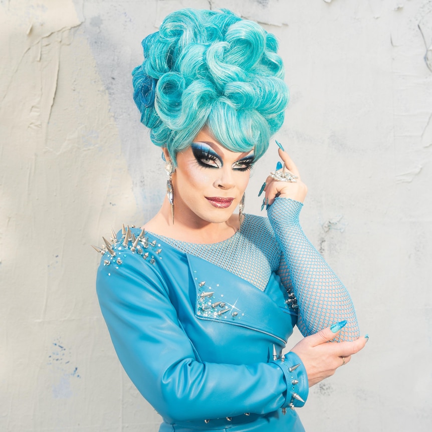 drag queen wearing blue wig, full black eye make-up and blue dress