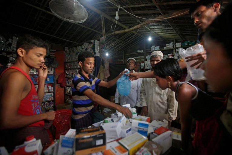 Rohingya refugees receive medicines at a makeshift pharmacy in the Kutupalong refugee camp