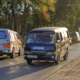 Small buses and trucks on a street with palm trees