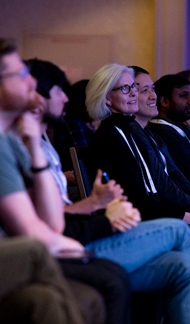 row of people sitting at a conference looking ahead