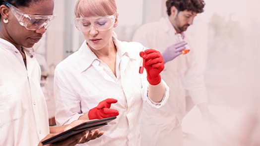 Lab workers with beakers and tablet using cloud computing