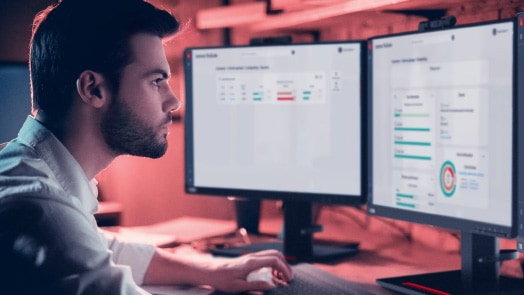 Homme sur son bureau avec deux écrans